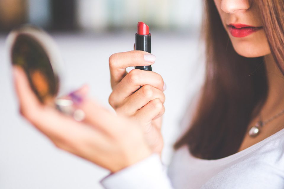 Foto: Frau mit Handspiegel und Lippenstift